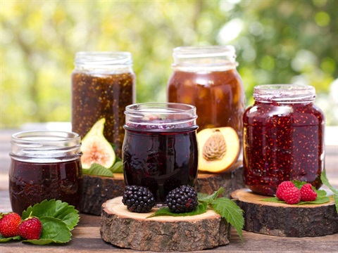 Jams and preserves displayed in jars with fresh fruit